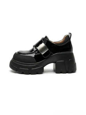 Black patent platform Mary Jane shoes with chunky lug sole, rounded toe, and adjustable strap