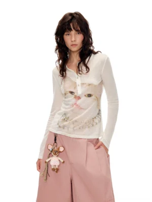 Pearl kitty portrait sheer Henley long sleeve top in ivory styled with pink wide leg pants in a streetwear studio look