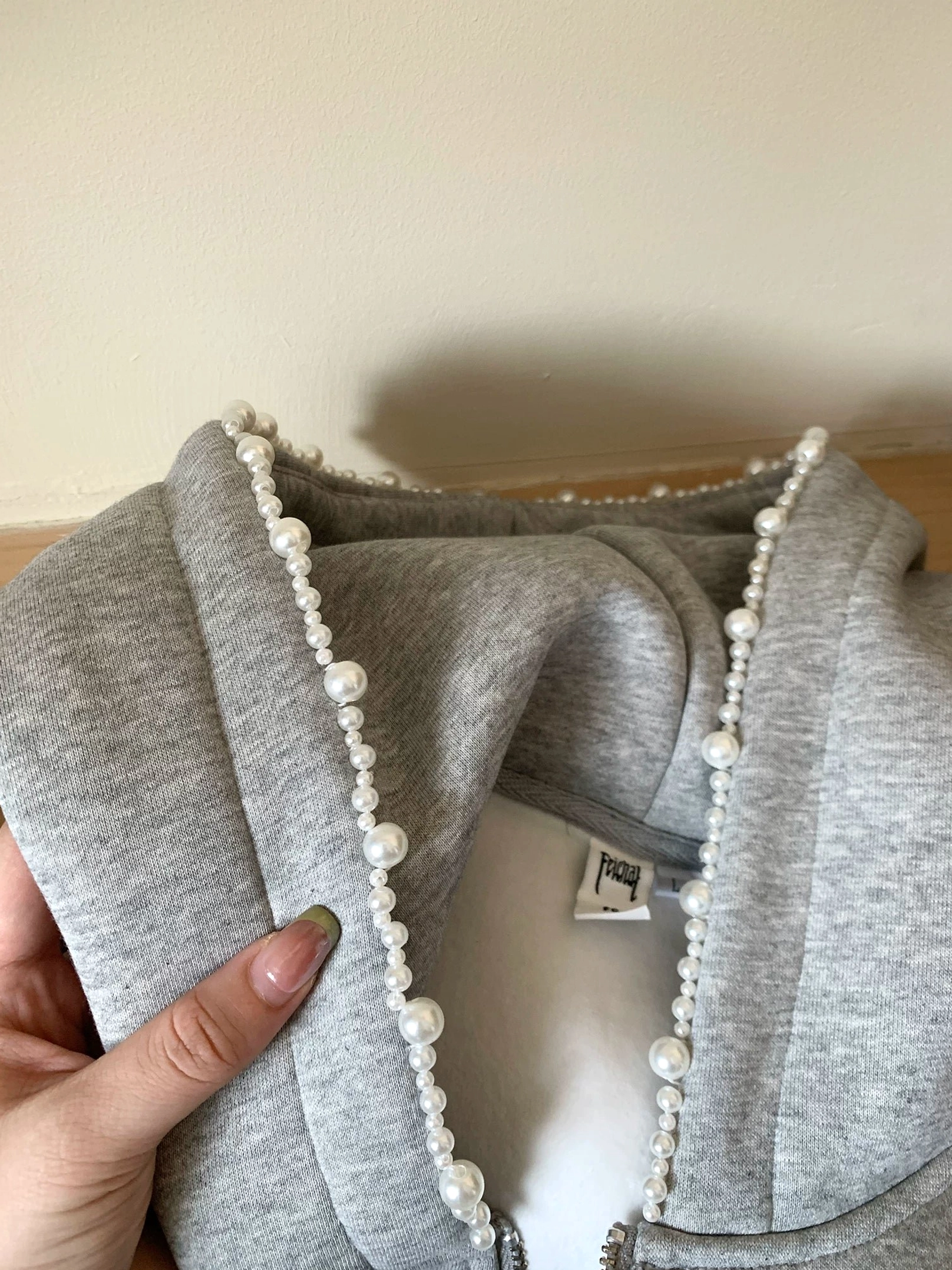 Close-up of heather gray pearl trim oversized zip-up cloud hoodie hood with faux pearl embellishment