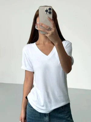 Pearl white women's relaxed V-neck rolled sleeve viscose knit tee styled with blue denim jeans