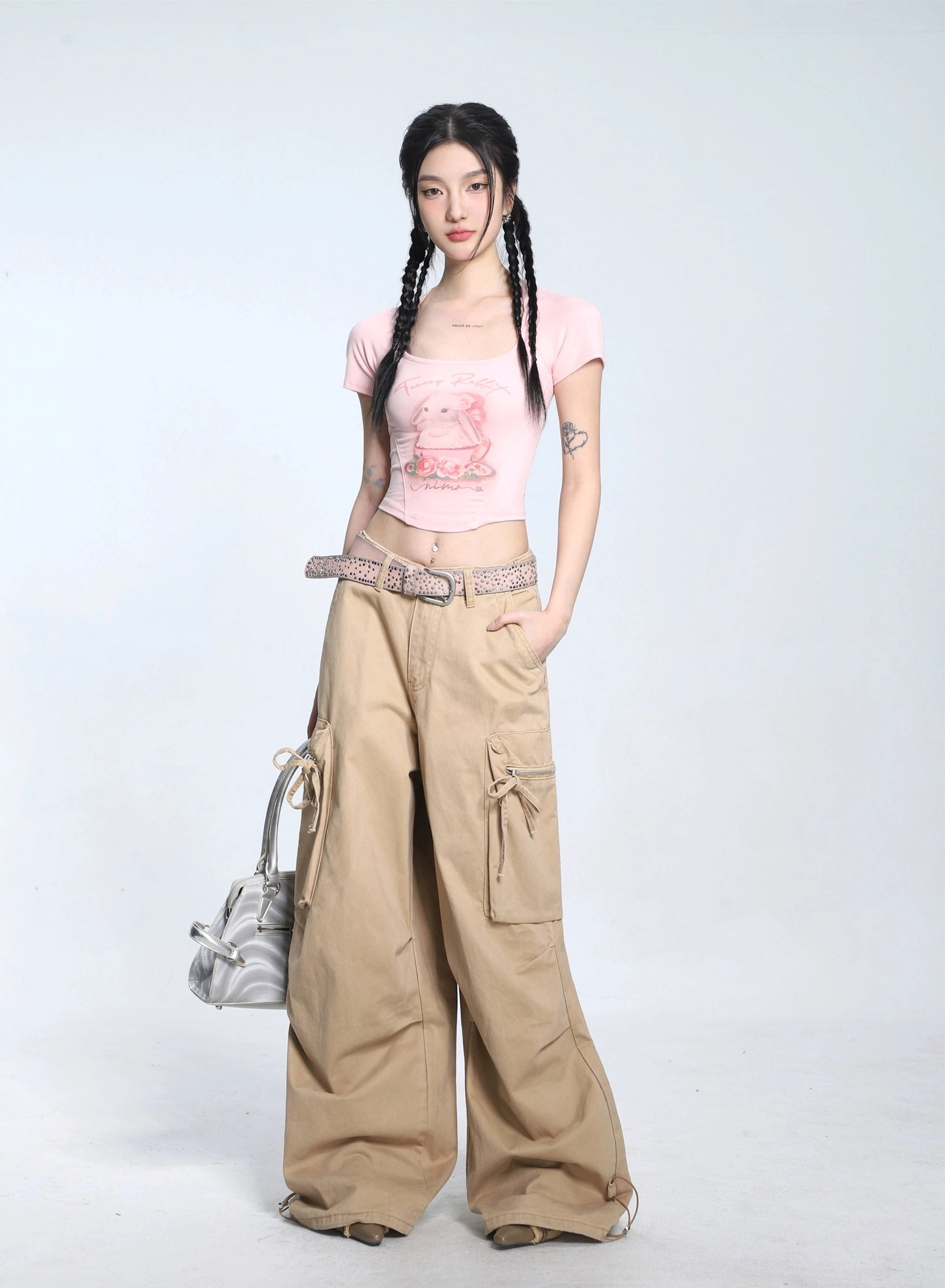 Pastel pink cropped bunny print short sleeve T-shirt with square neckline styled with khaki wide-leg cargo pants and silver shoulder bag