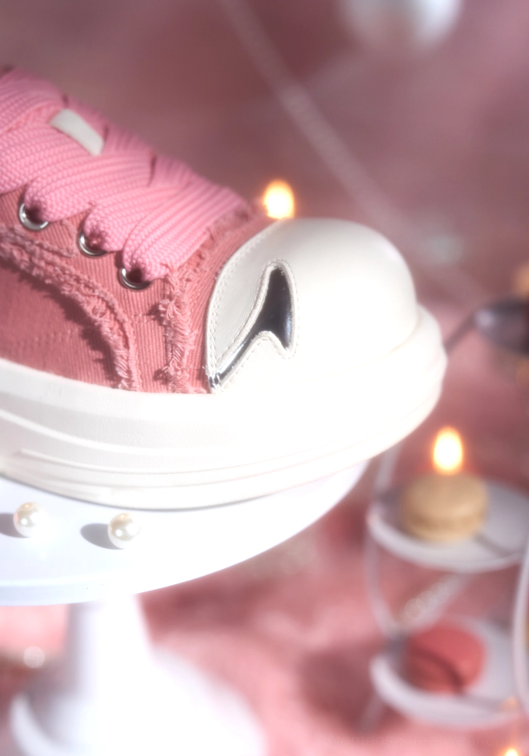 Front side close-up of pink canvas platform skate sneaker highlighting frayed texture, silver side detail, rounded toe, and chunky white rubber sole