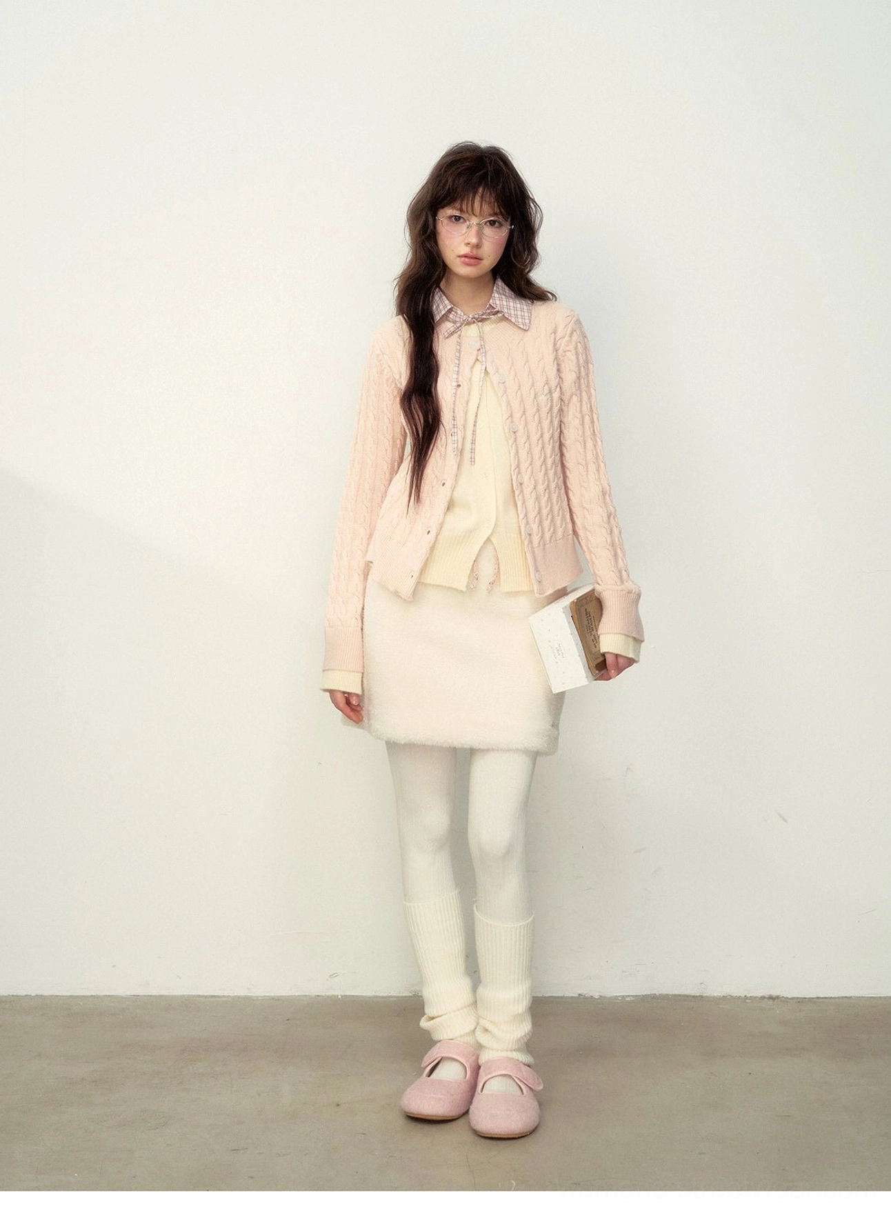 Pink cropped cable knit preppy cardigan with button closure styled with an off-white skirt and flats