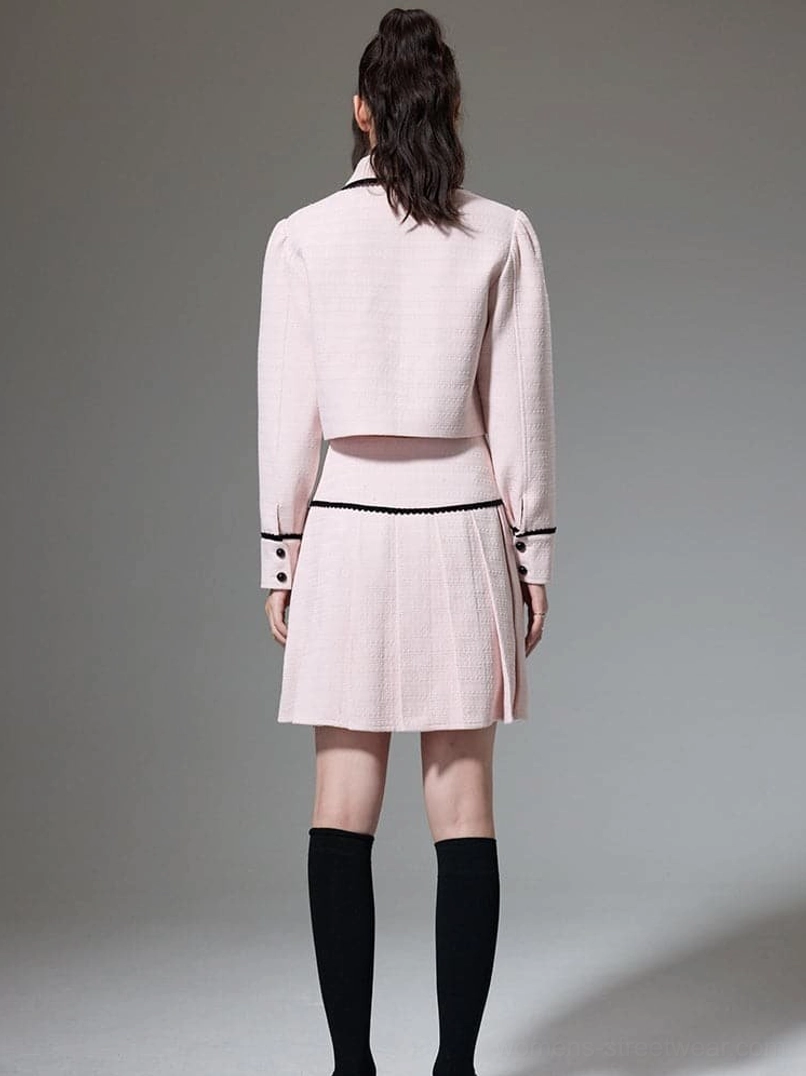Back view of coordinated pink cropped jacket and pleated mini skirt tailored streetwear outfit