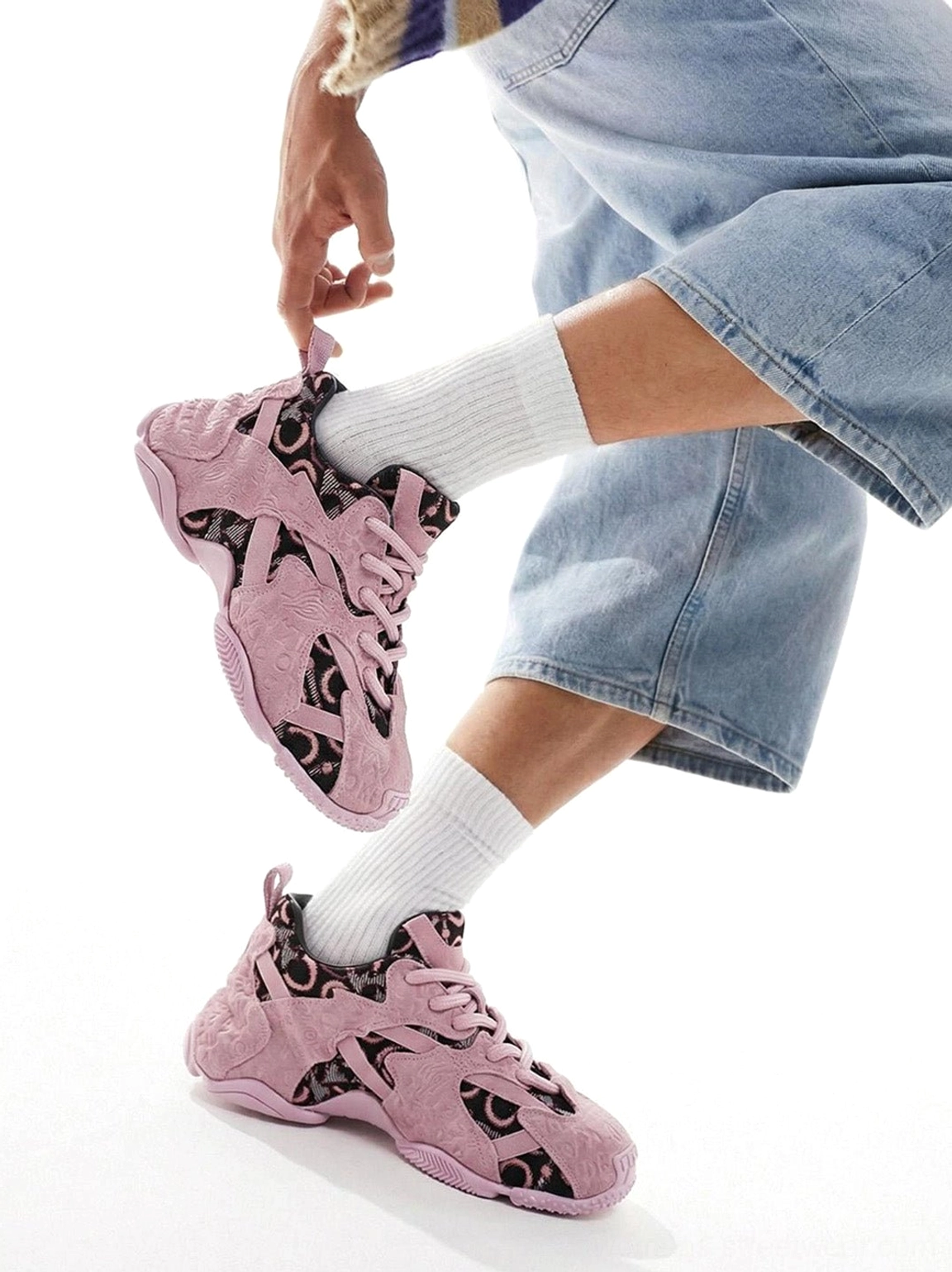 Model wearing pink embroidered chunky dad sneakers with cropped denim jeans and white crew socks in a casual streetwear outfit