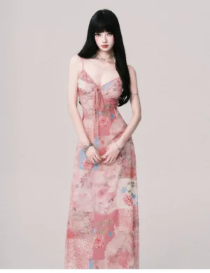 Pink floral patchwork maxi dress shown from the front with gathered sweetheart neckline, lightweight flowing skirt, adjustable straps, and delicate jewelry styling