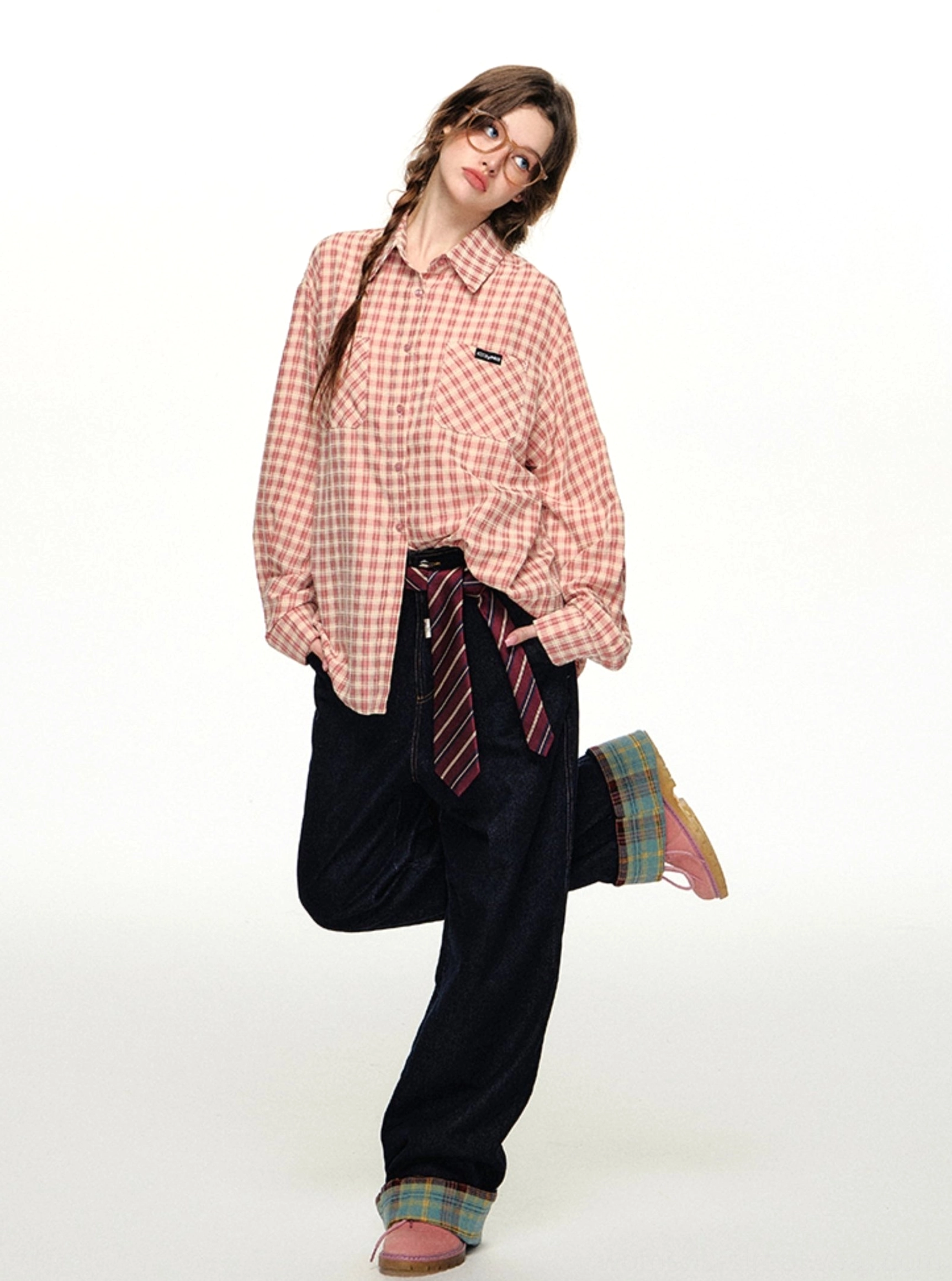 Pink gingham button-up streetwear shirt fully fastened and styled with dark wide-leg pants and pink flats