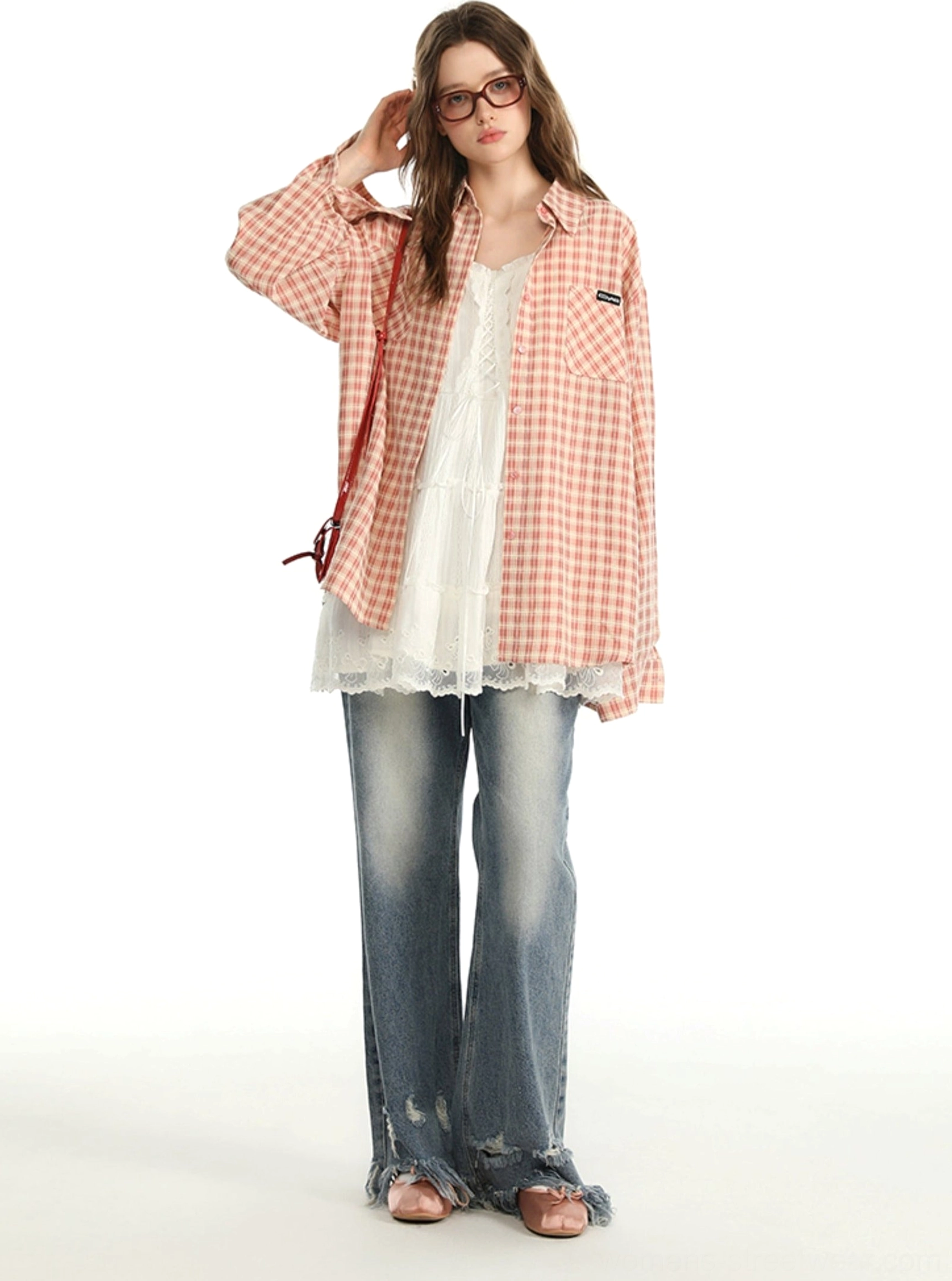 Pink gingham casual button-up shirt with a loose boyfriend fit styled with frayed hem jeans and a red crossbody bag