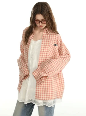 Three-quarter view of a pink gingham oversized shirt layered over a white lace camisole dress with casual denim styling
