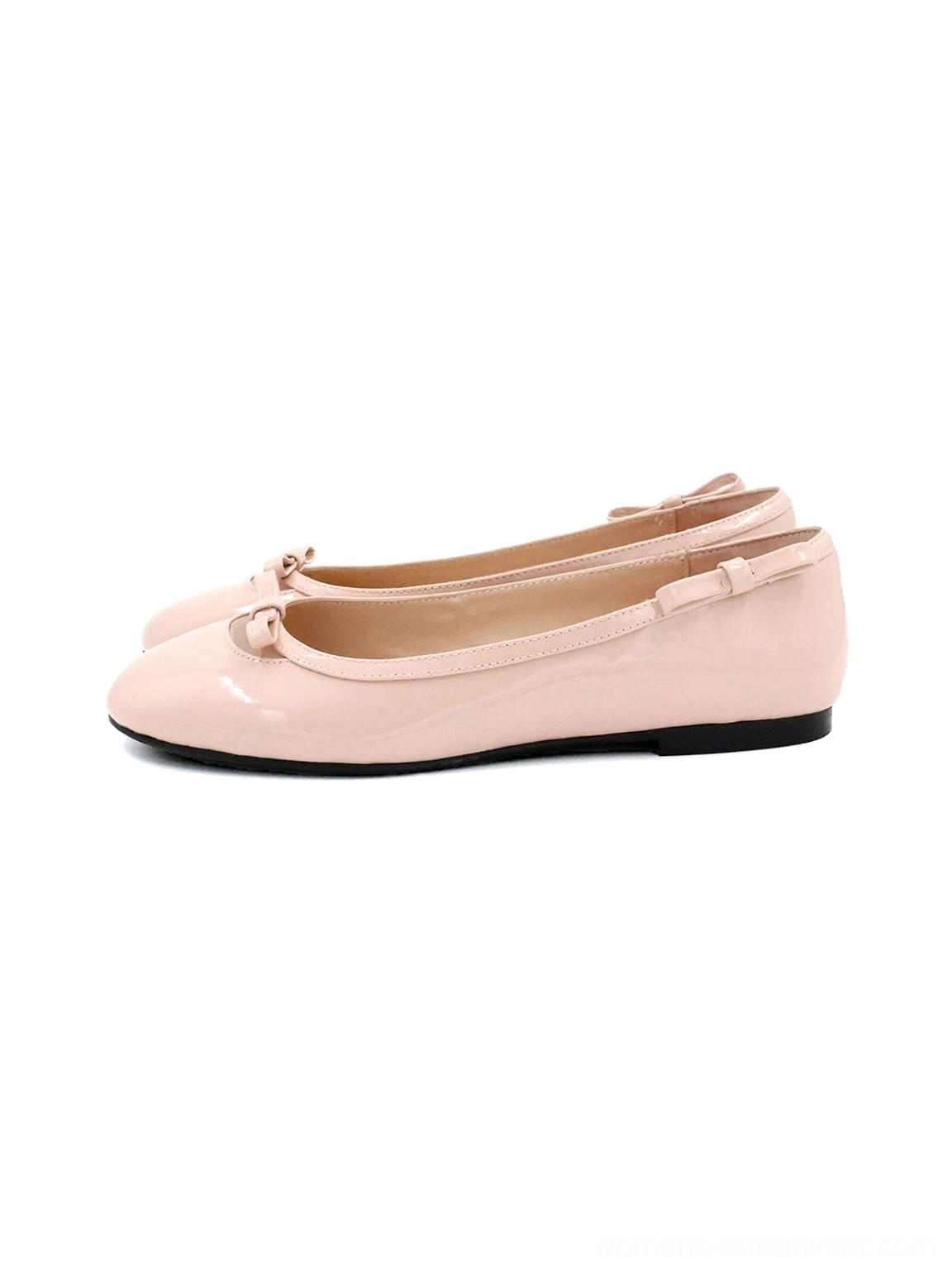 Soft pink patent leather bow ballet flats in side profile with glossy finish, rounded toe, ruffled heel trim, black flat sole, and balletcore styling