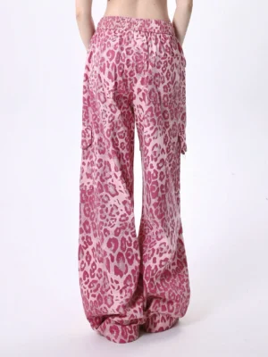 Back view of pink leopard print cargo pants showing elastic waistband roomy rear fit and loose wide leg silhouette for Y2K streetwear styling