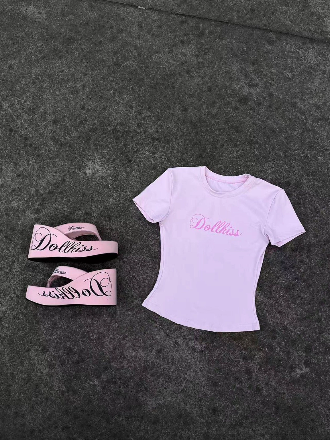 Pink logo print platform wedge flip-flop design displayed in a miniature styling flat lay with pink fitted t-shirt