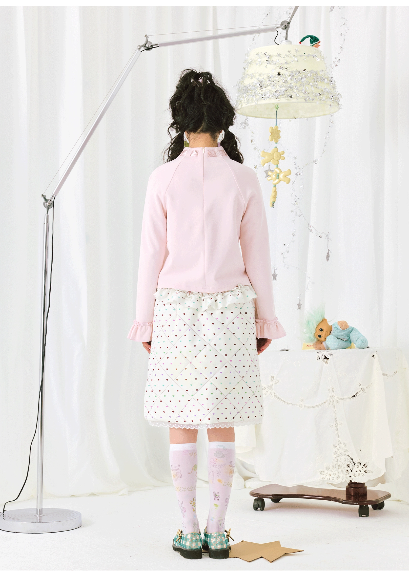 Back view of a pink long sleeve ruffle top showing the solid pastel back and relaxed raglan-inspired silhouette