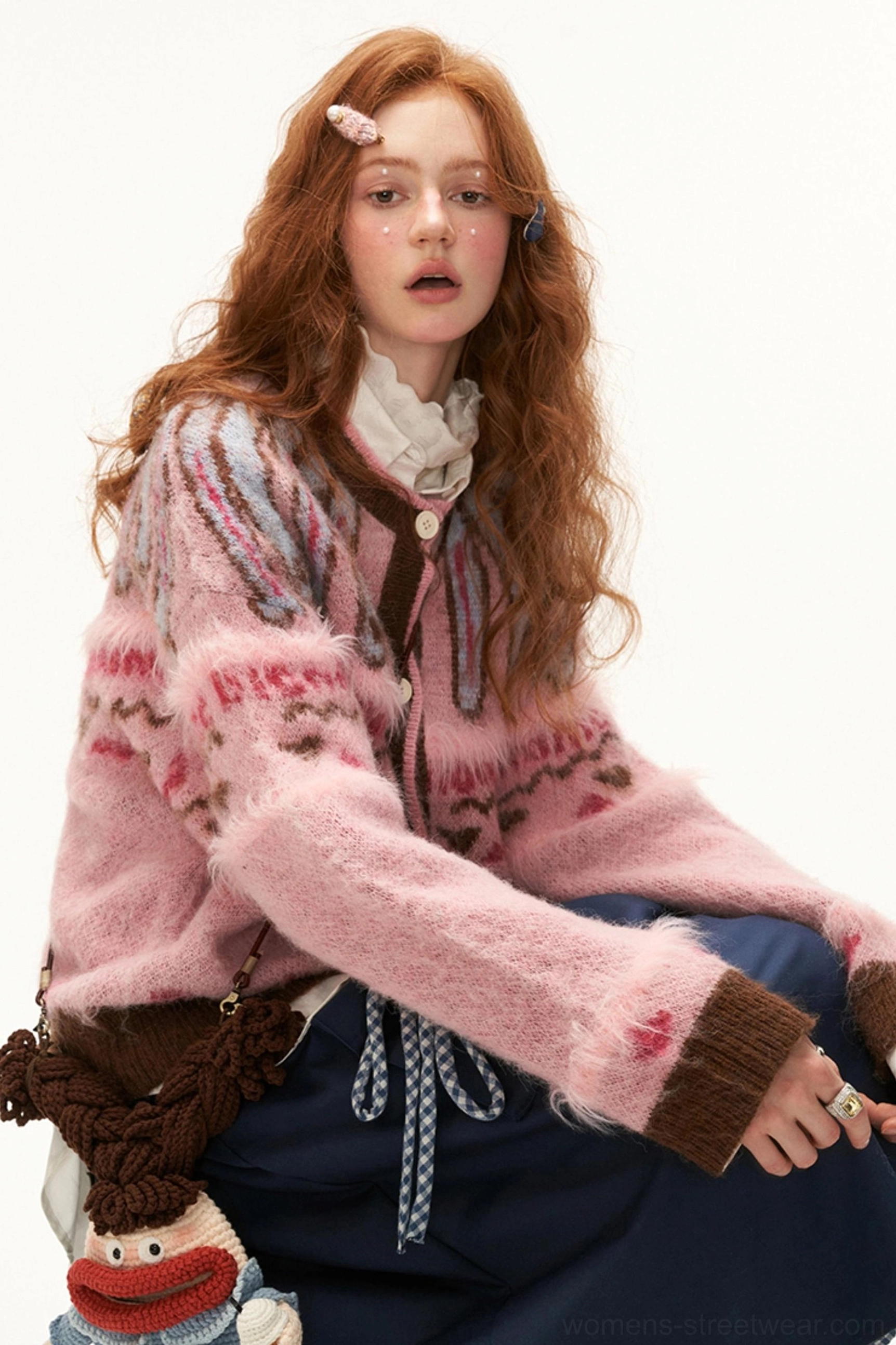 Pink Fair Isle mohair heart cardigan styled in a seated Korean streetwear outfit with navy drawstring pants