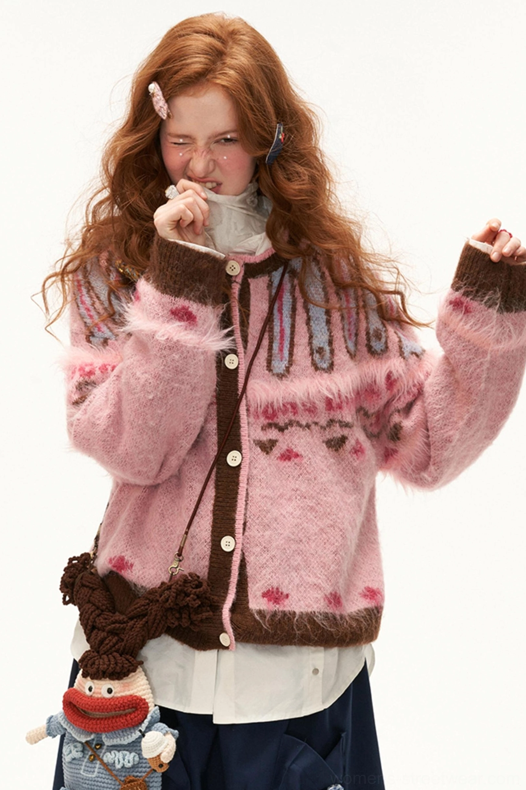 Pink fuzzy mohair Fair Isle cardigan three-quarter view showing heart jacquard pattern and ribbed brown cuffs