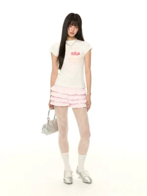 Pink multi-tiered ruffle mini shorts with a cake print short tee and floral fishnet tights shown in a three-quarter Korean streetwear outfit