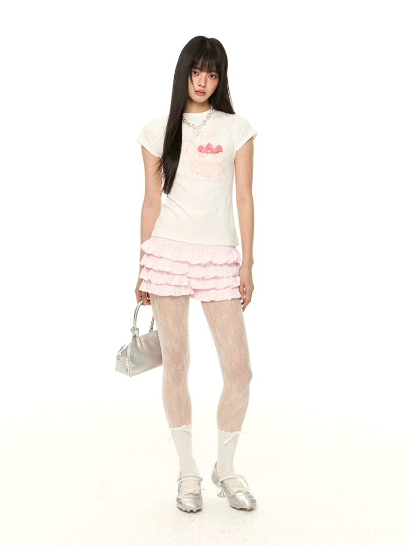 Pink multi-tiered ruffle mini shorts with a cake print short tee and floral fishnet tights shown in a three-quarter Korean streetwear outfit