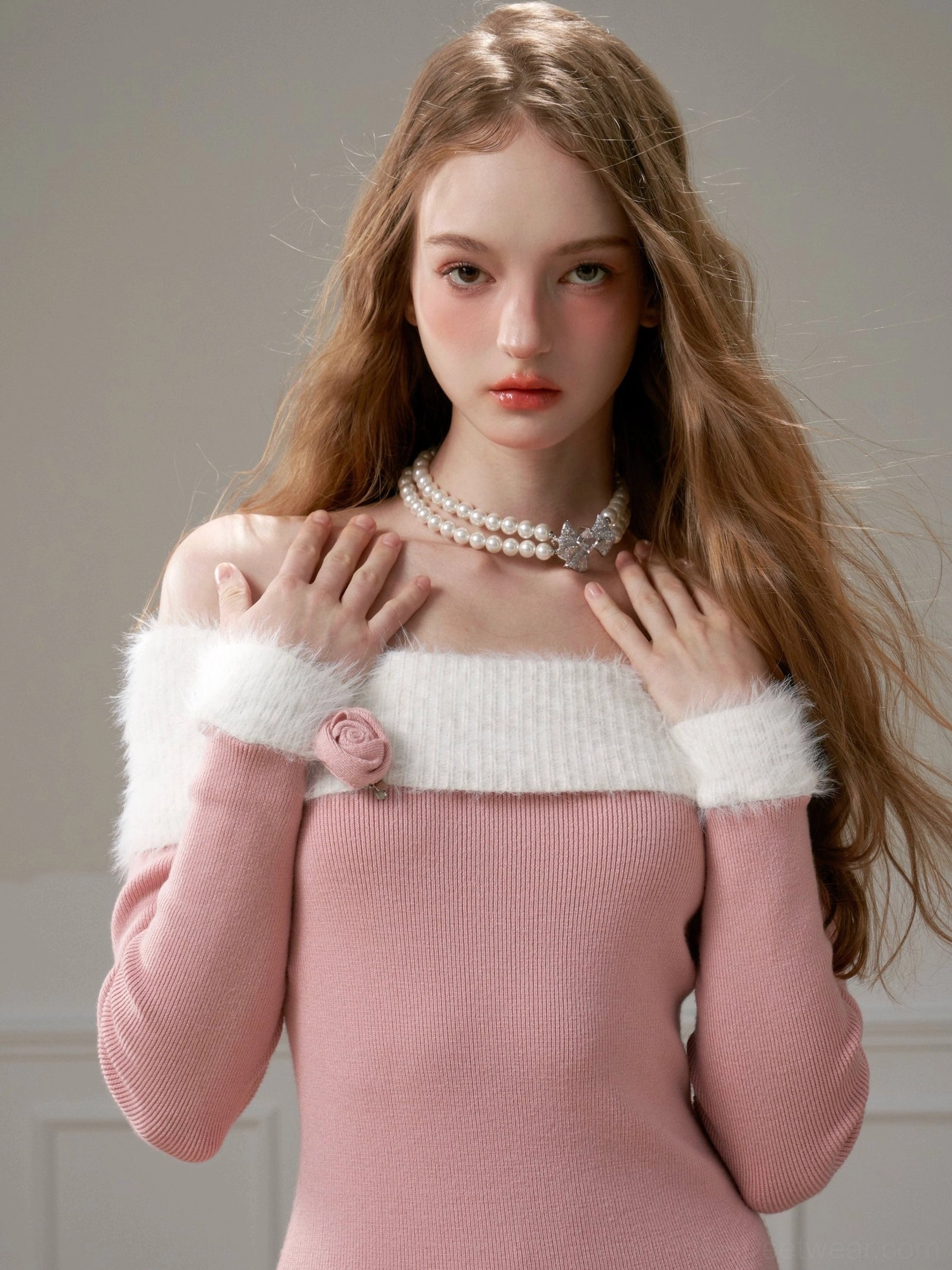 Close-up of pink off-shoulder knit dress showing dimensional rose neckline embellishment, white fuzzy trim, ribbed texture, and sleeve cuff