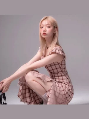 Pink plaid asymmetric midi dress with flutter sleeves and ruffled hem styled with a black handbag