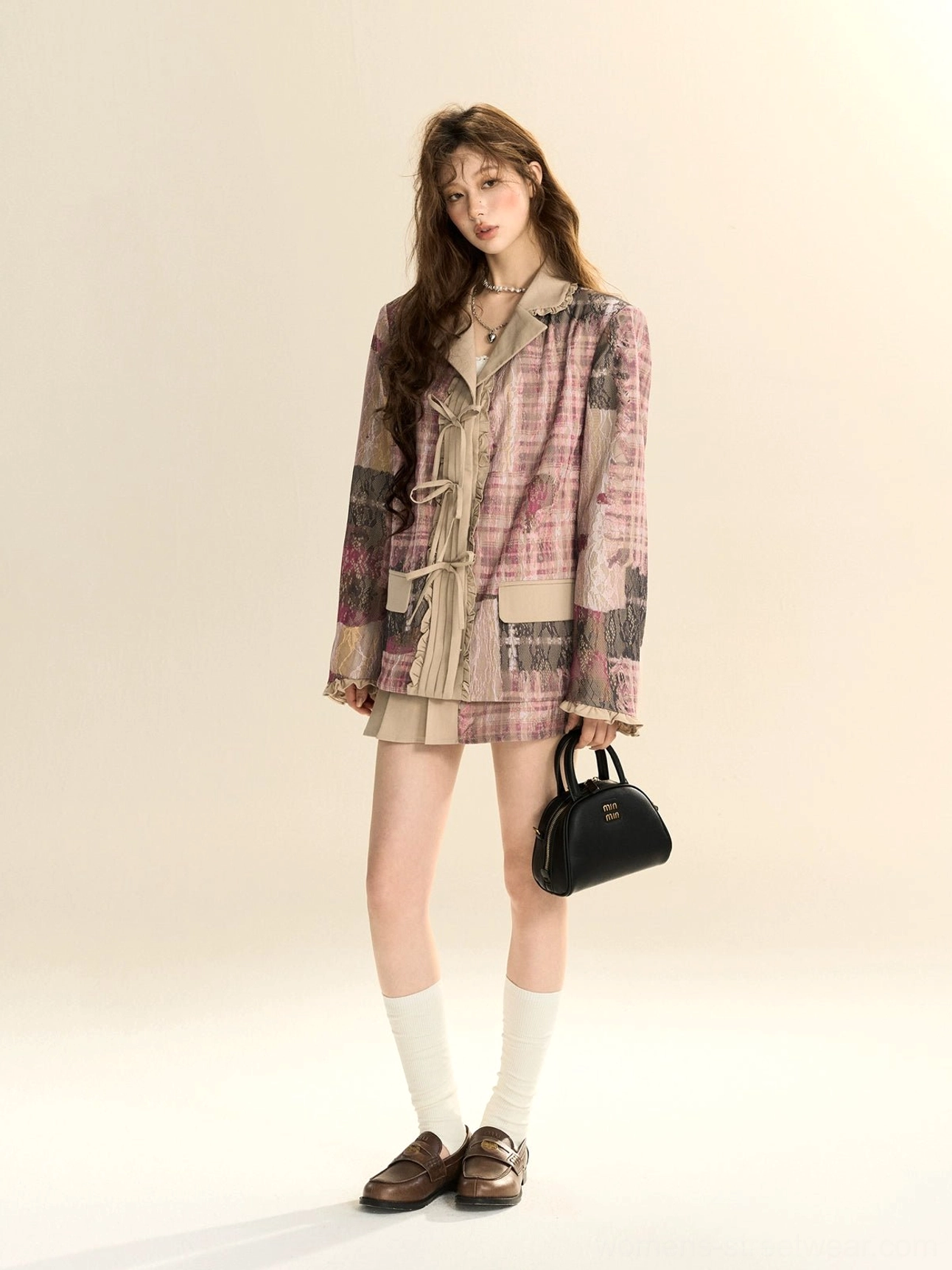 Front outfit view of a pink plaid blazer and pleated mini skirt with beige accents, black handbag, white socks and brown loafers