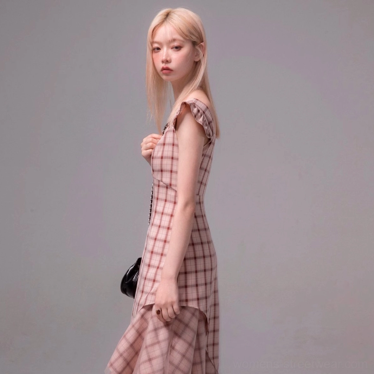 Side view of a fitted pink plaid midi dress with short ruffled sleeves and high-low asymmetric skirt