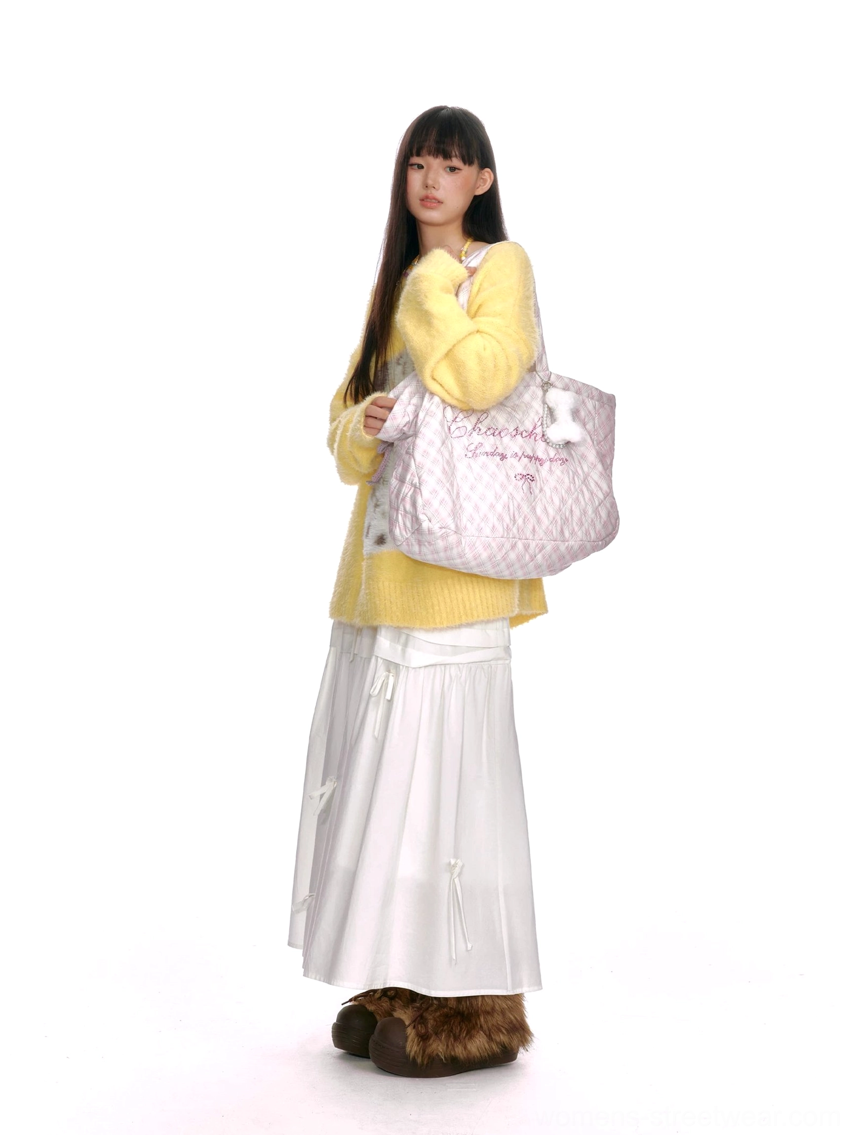 Pink plaid oversized quilted tote bag with decorative lettering and fluffy bone charm styled with a yellow knit streetwear outfit