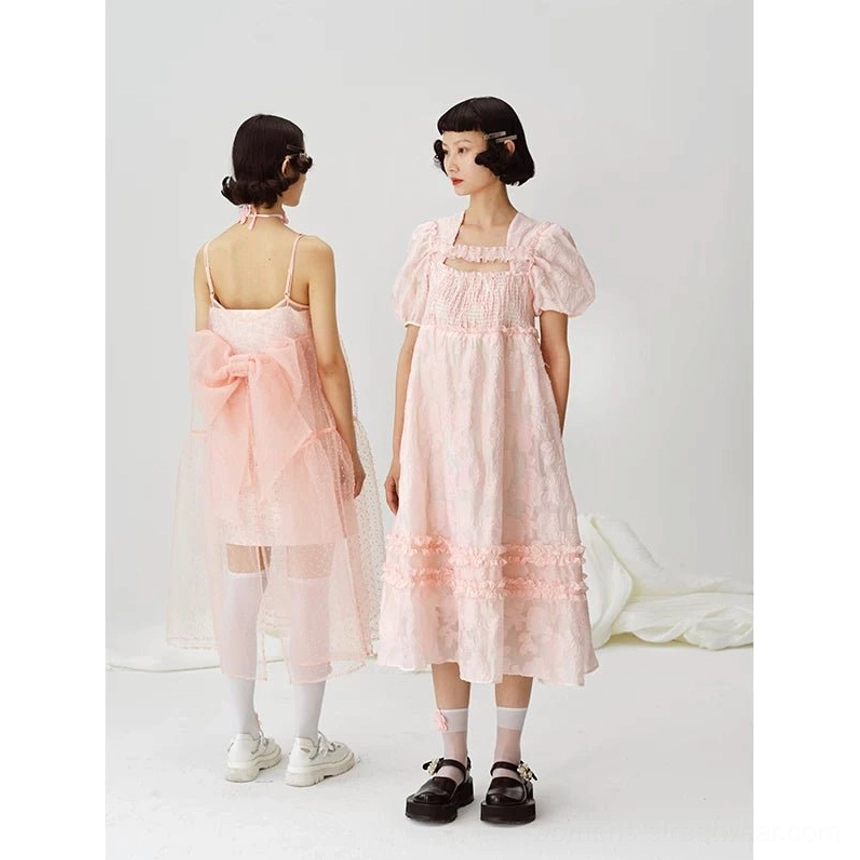 Back view showing the pink puff sleeve midi dress styled beside a contrasting backless bow dress with a sheer tulle skirt