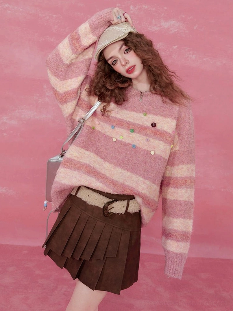 Pink striped fuzzy knit sweater with colorful buttons styled with a brown pleated mini skirt in a pink studio