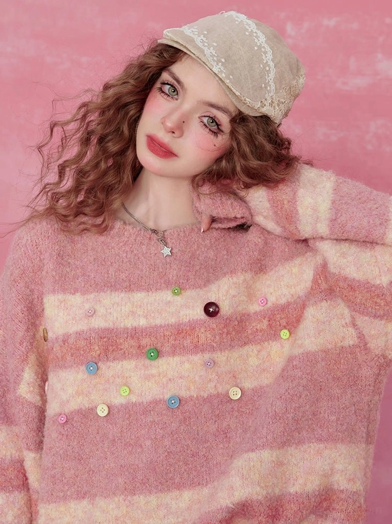Close-up of pink striped fuzzy knit sweater showing colorful decorative buttons and soft brushed texture
