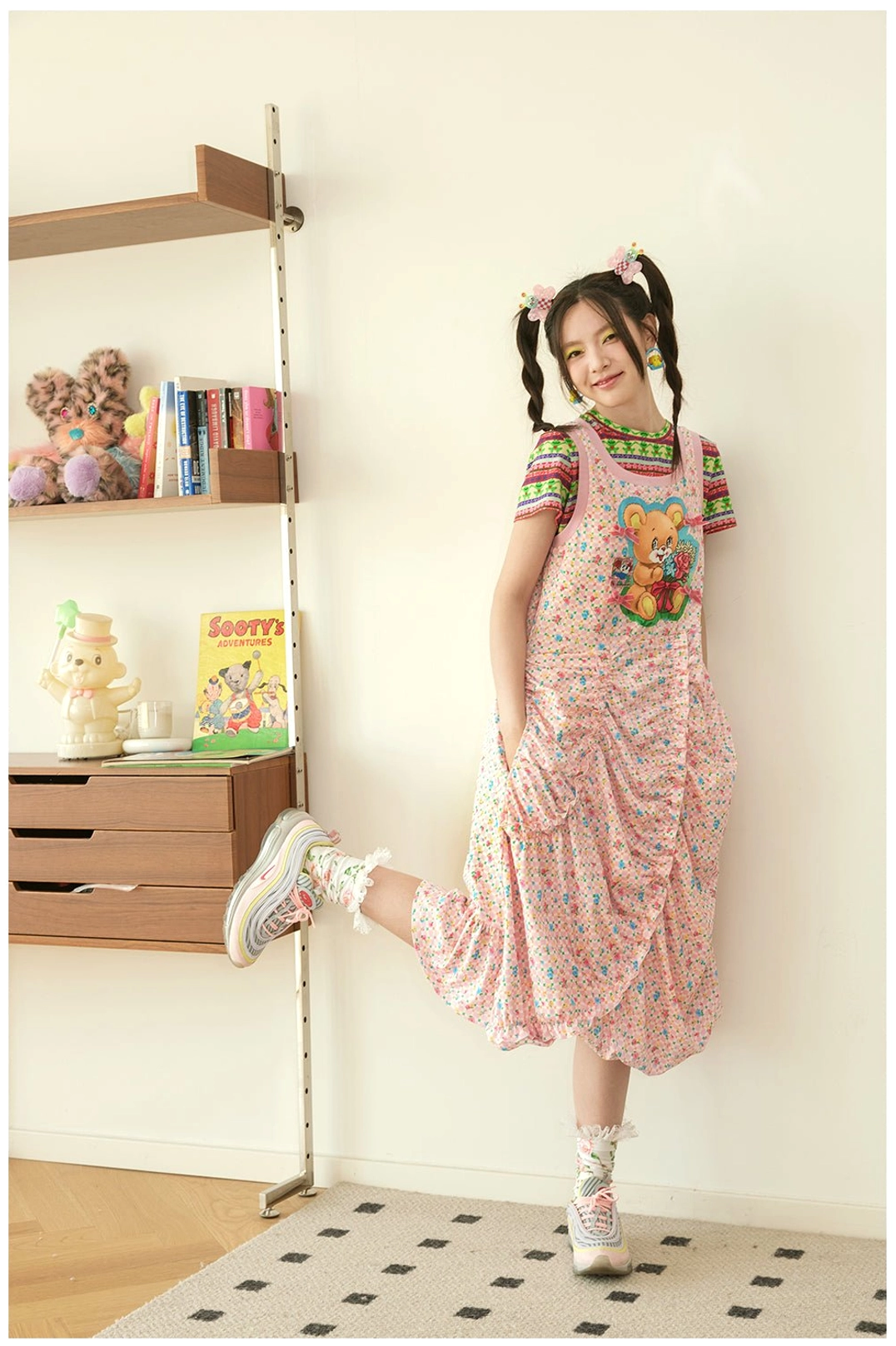 Side view of pink teddy bear floral ruched midi pinafore dress layered over a striped tee for Korean streetwear styling