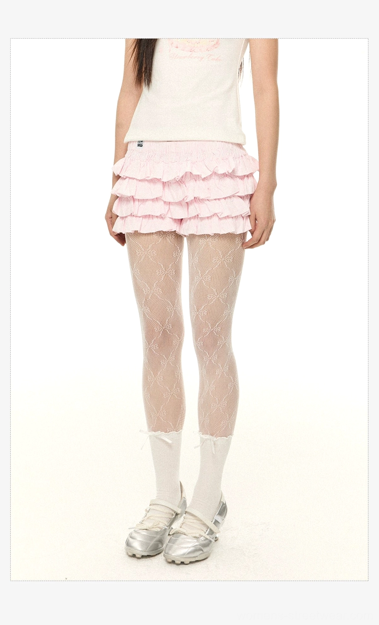 Pink tiered ruffle mini shorts styled with a cake print short sleeve tee, floral fishnet tights, white socks, and silver loafers