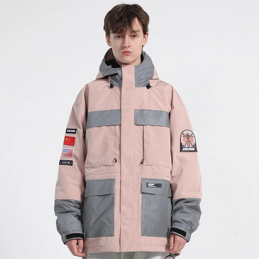 Pink unisex reflective panel ski jacket front view featuring flap cargo pockets, sleeve patches, adjustable Velcro cuffs, and drawcord hood