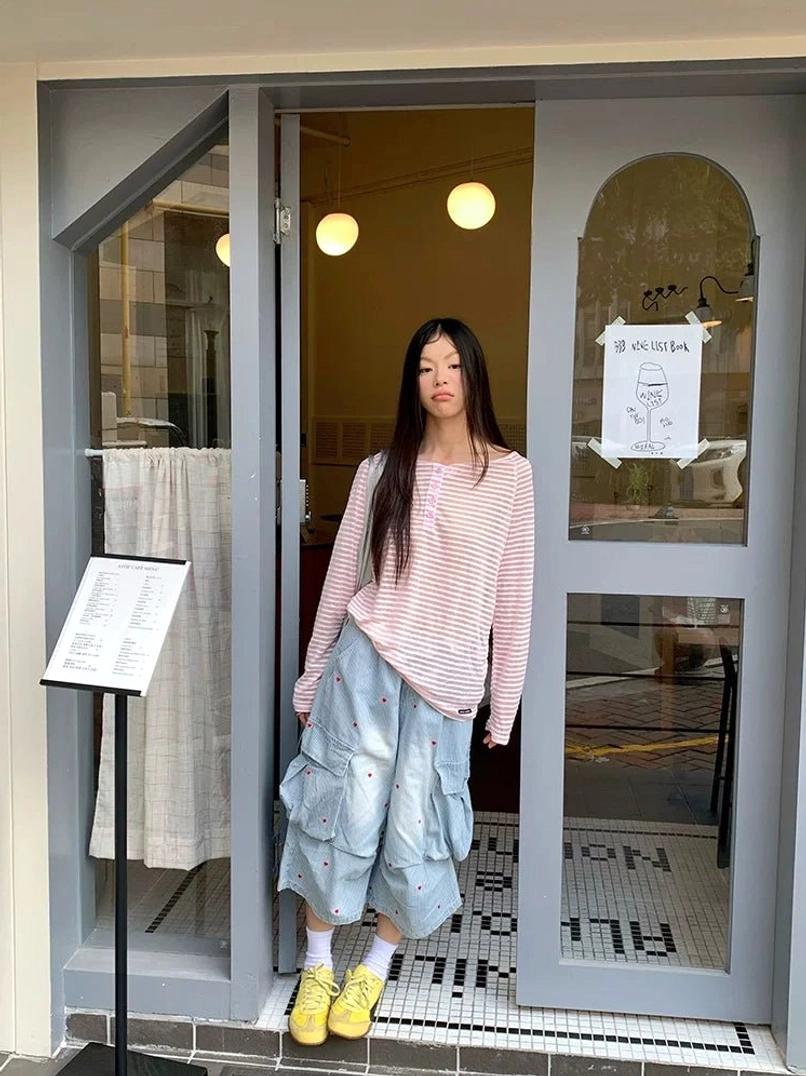 Full body outfit with pink white striped off-shoulder long sleeve tee, cropped cargo jeans and yellow sneakers