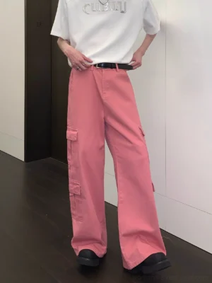 Front three-quarter view of dusty pink wide-leg cargo pants styled with a white graphic T-shirt black belt and black loafers