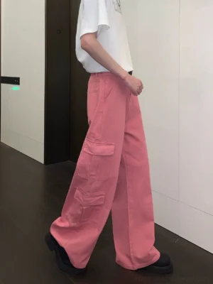 Rear side view of dusty pink streetwear cargo pants showing layered flap pockets and a relaxed wide-leg silhouette