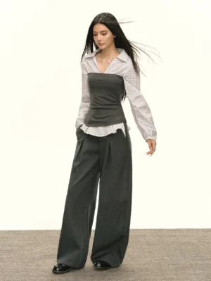 Three-quarter view of a coordinated plaid shirt bustier outfit with dark gray wide-leg trousers and black leather shoes