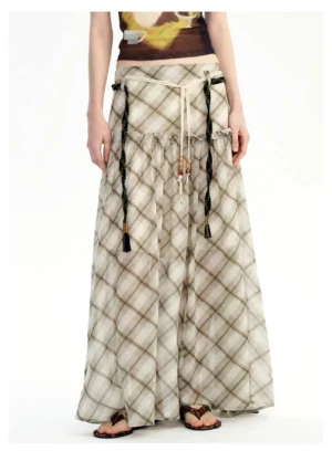 Front close-up of a neutral plaid chiffon maxi skirt with ruched high waist, tassel drawstrings, and flowing streetwear silhouette