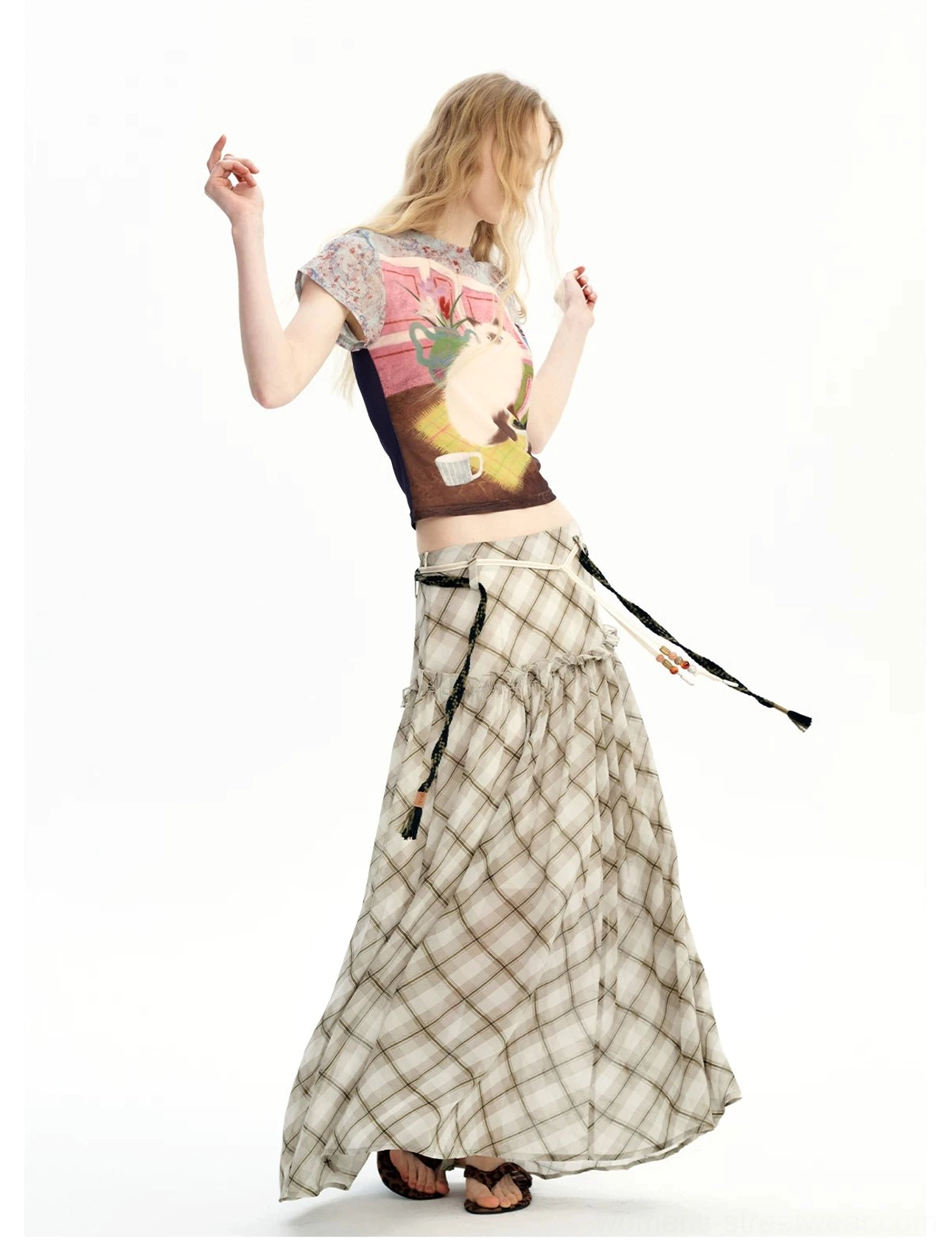 Side view of a plaid chiffon maxi skirt with long decorative tassel drawstrings and relaxed streetwear styling