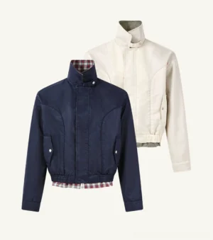 Flat lay of navy blue and off-white plaid-lined Harrington jackets showing stand collars, tartan lining, snap closures, and flap pockets