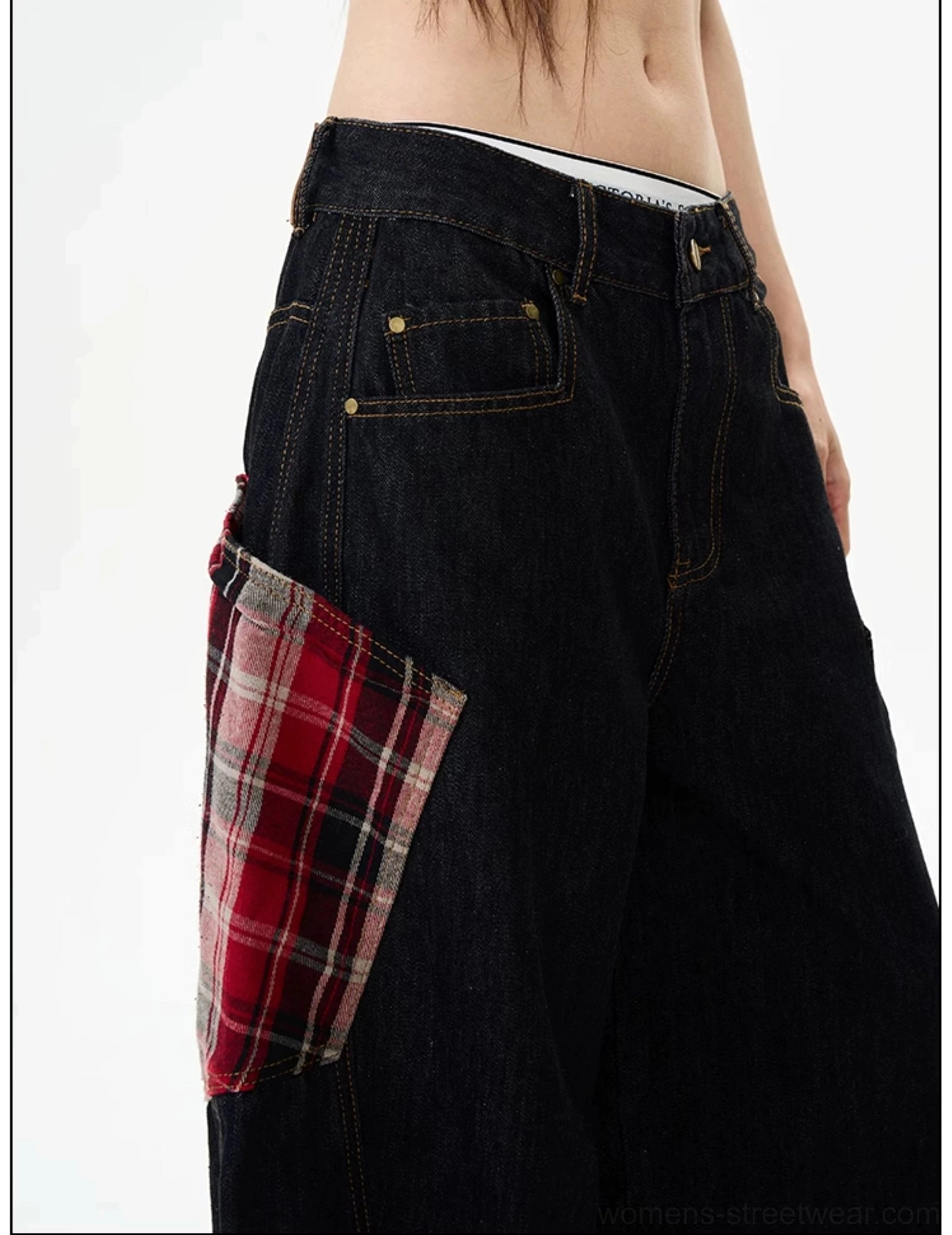 Close-up of plaid patch denim cargo pants waistband and side pocket with metal button, rivets, and detailed streetwear hardware