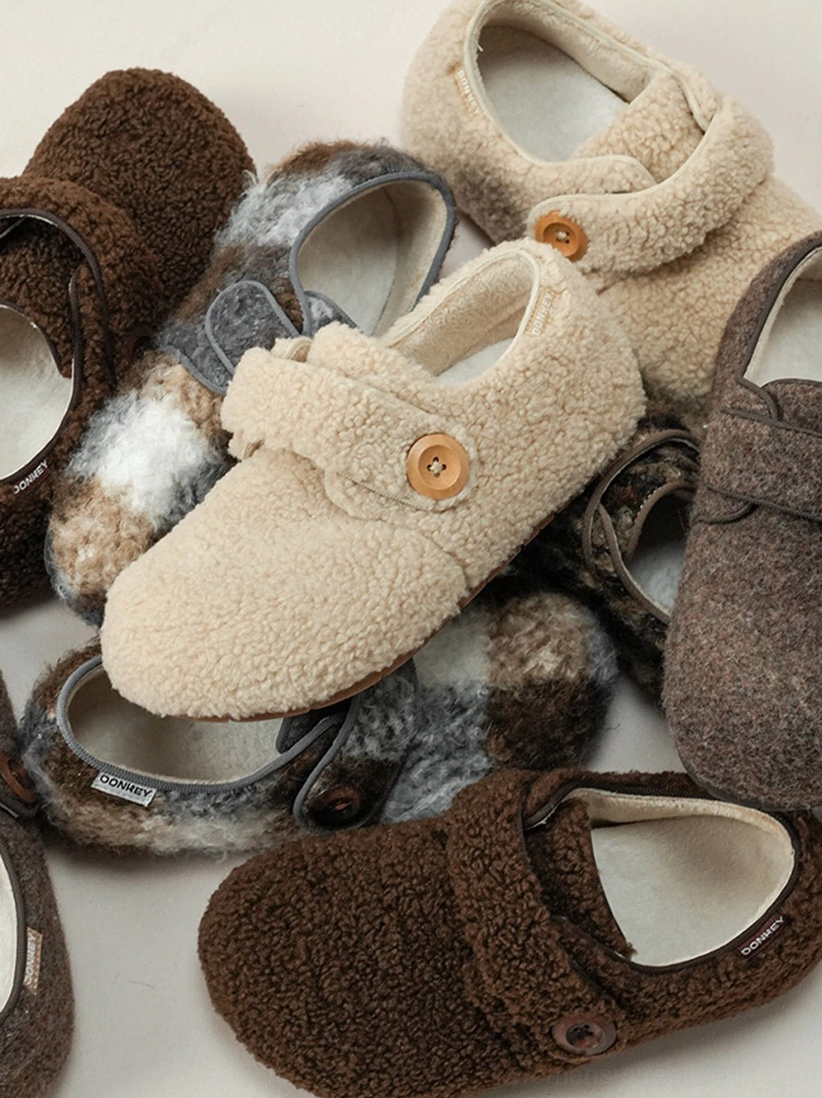 Close-up view of plush faux fur Velcro slip-on shoe texture rounded toe smooth insole and adjustable strap construction