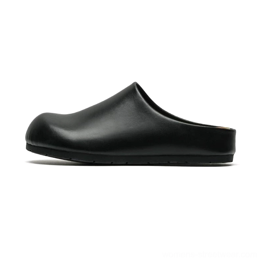 Polished black leather-look closed-toe mule clogs shown in side profile with sleek rounded toe, open heel, and low flat sole