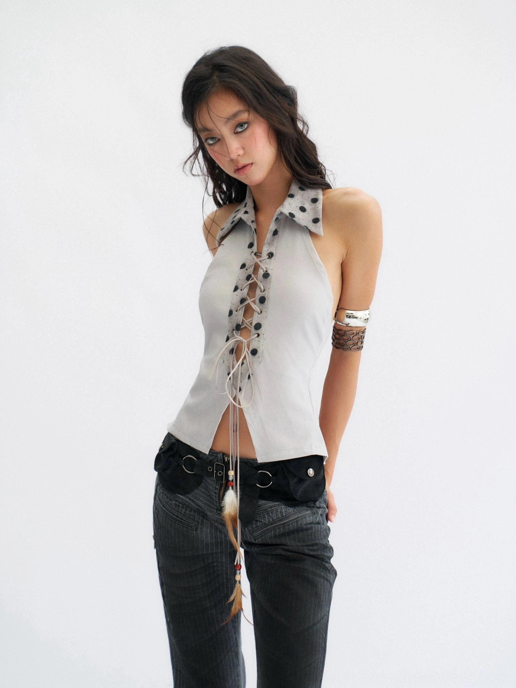 Front side view of a fitted polka dot collar lace-up halter top with split hem and decorative tassel for Y2K streetwear styling
