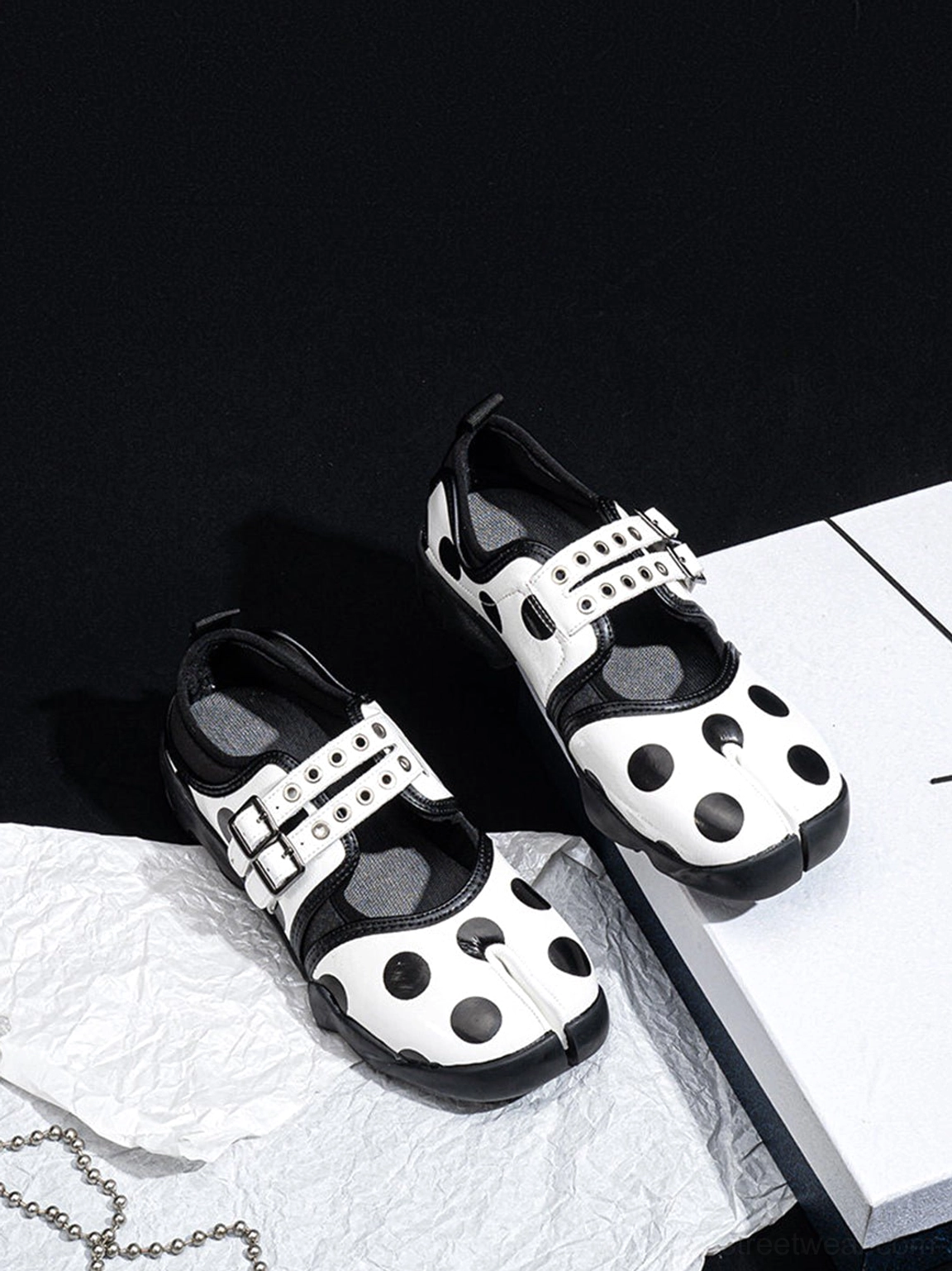 Overhead view of polka dot Mary Jane sneakers highlighting metal buckle fastenings and split-toe construction