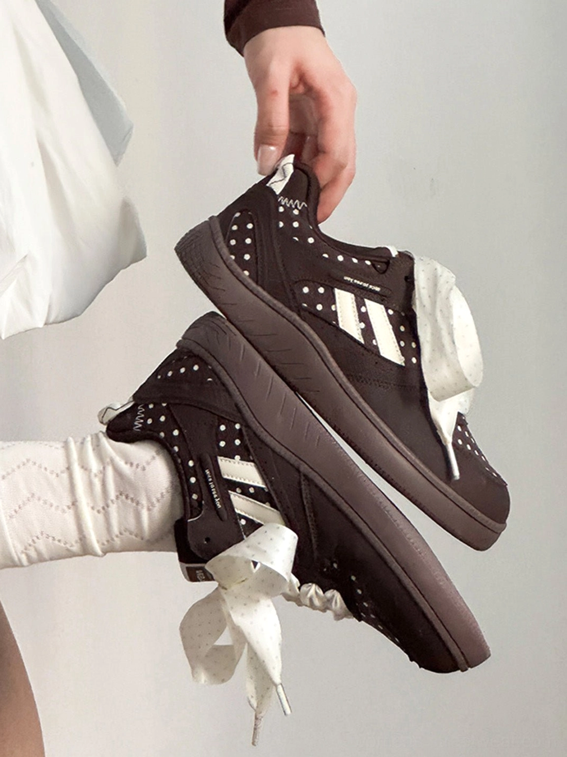 Polka dot ribbon low top skate sneakers in a streetwear-inspired product presentation