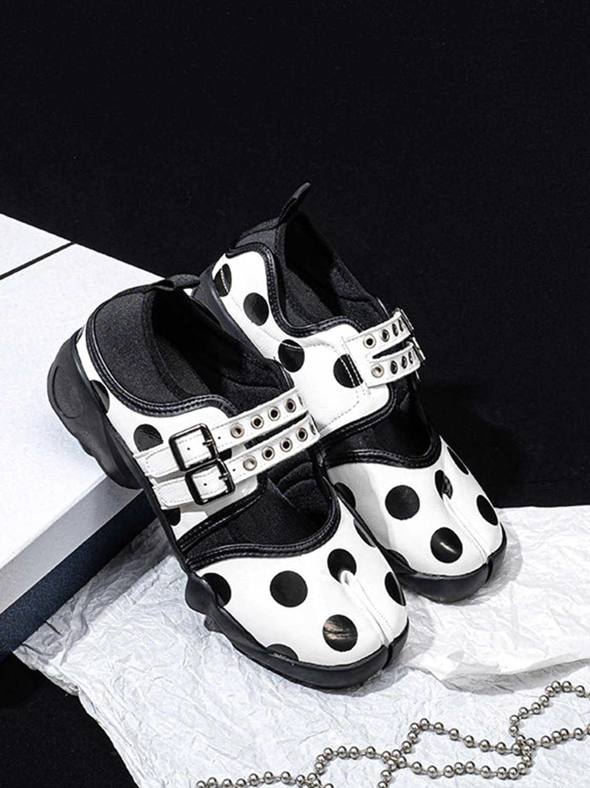 Flat lay of polka dot split-toe Mary Jane shoes with double straps and chunky rubber soles