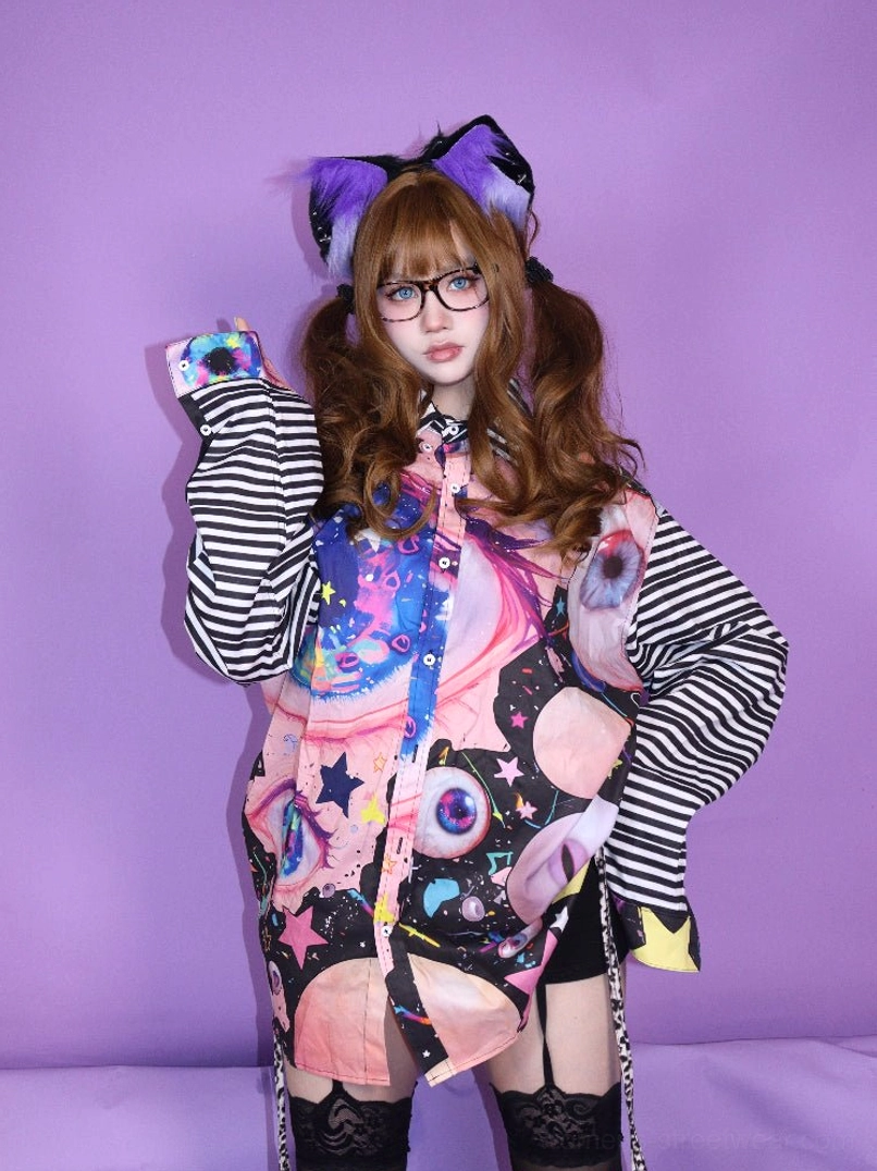 Front upper body view of cosmic eye graphic striped sleeve button shirt in Harajuku Y2K streetwear styling