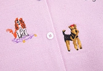 Close-up of puppy embroidery colorful knit texture and white button on the embroidered knit cardigan