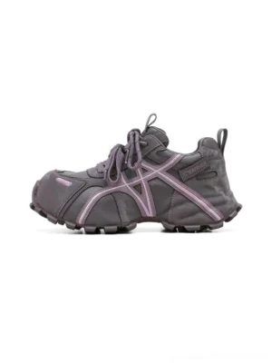 Dark purple women’s technical trail sneakers with cross-lace cage, layered synthetic panels, chunky segmented sole, and heel pull tab