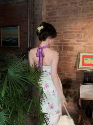 Back view of purple floral halter qipao midi dress with open tie back and ivory orchid print